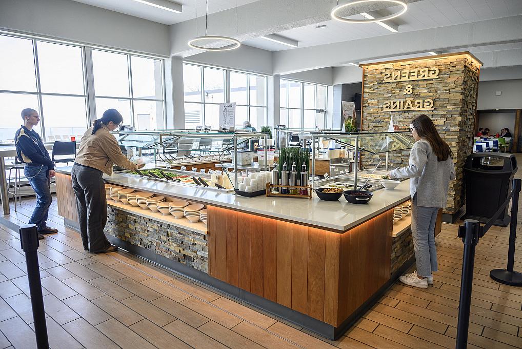 Students grabbing food from the salad bar in the cafeteria.